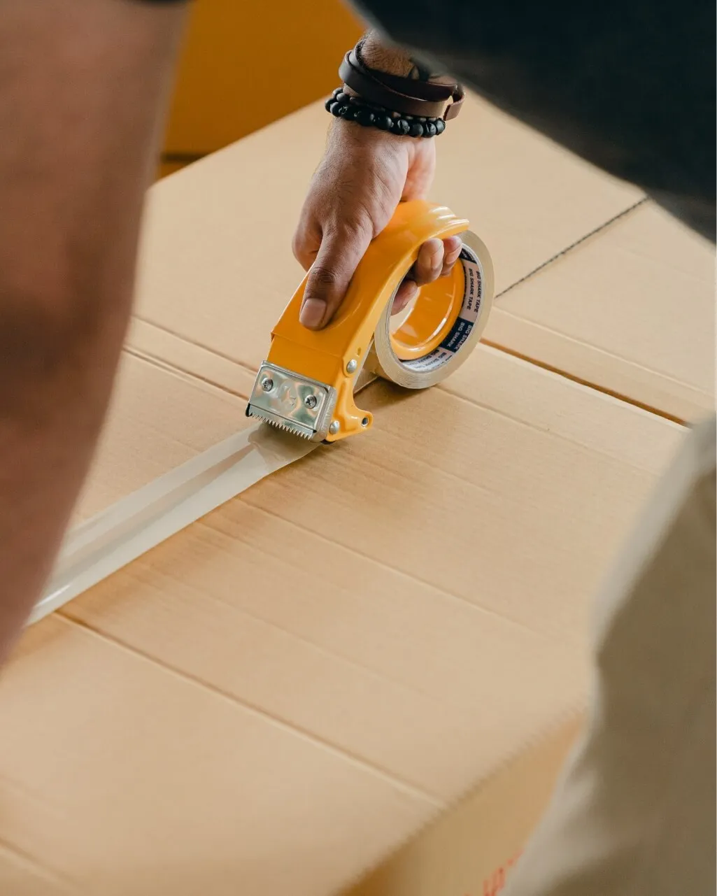 Man using tape to close a cardboard box